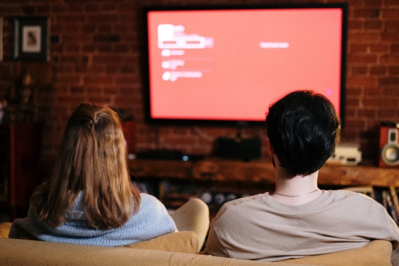 Learn English grammar
An image showing two persons facing a television